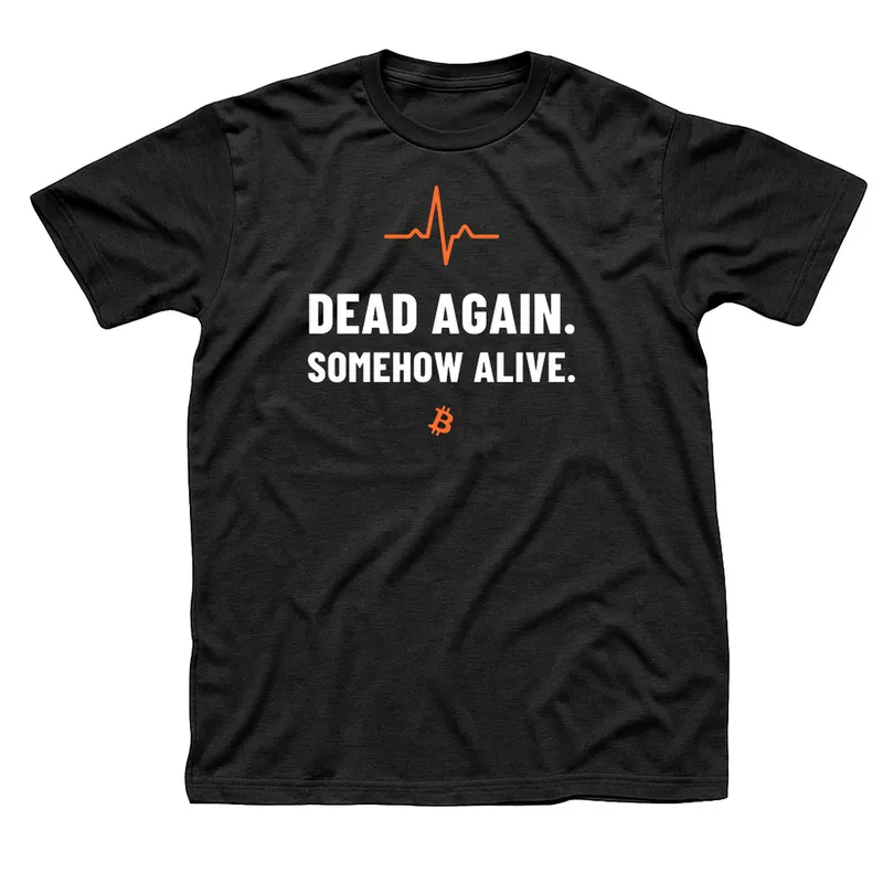 Black t-shirt with an orange heartbeat line above Dead Again, Somehow Alive in white capitals and a small orange Bitcoin symbol below