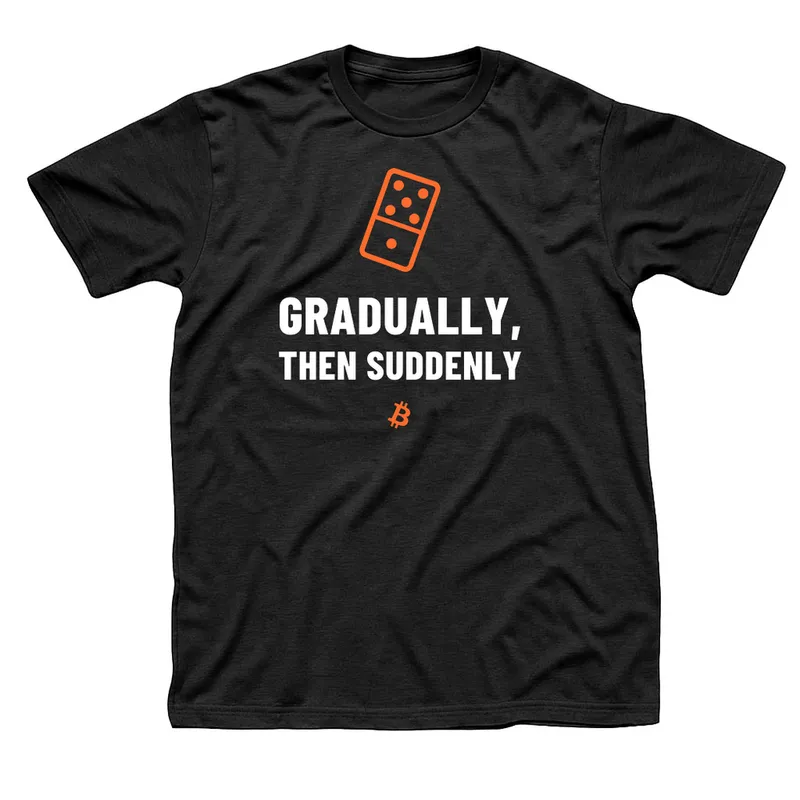 Black t-shirt with a tilting orange domino above Gradually, Then Suddenly in white capitals and a small orange Bitcoin symbol below