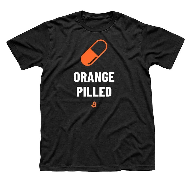 Black t-shirt with an orange two-tone capsule above Orange Pilled in white letters